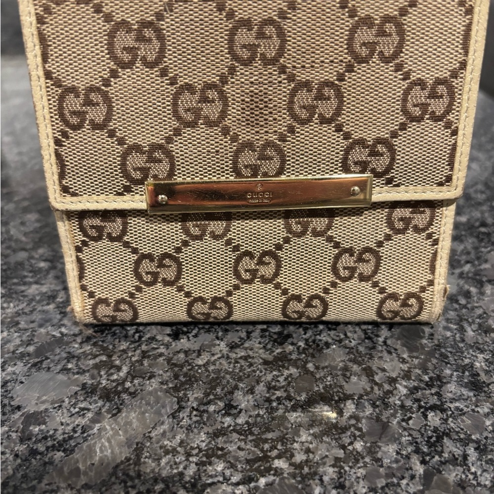 Gucci GG canvas bifold compact wallet in beige and brown.